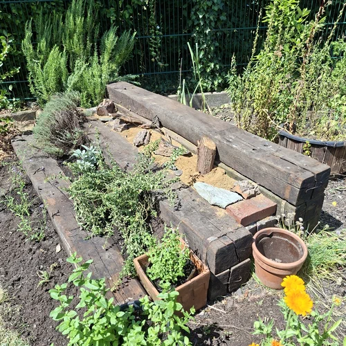 Ein Sandarium, gebaut aus alten Bahnschwellen in Treppenform. Die untere Ebene fungiert als Kräutergarten, die obere Ebene ist mit Sand und Lehm für Schmetterlinge ausgelegt.