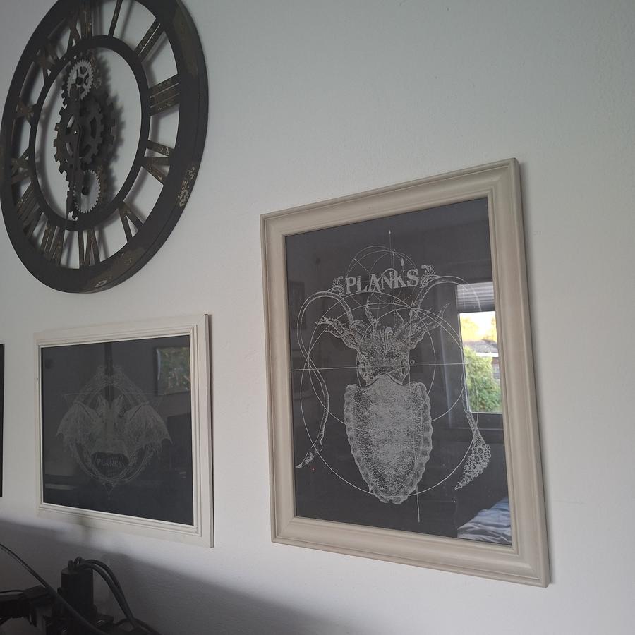 Ein Foto von zwei eingerahmten Backpatches der Gruppe Planks.